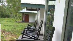 Filare di panche di legno su un patio coperto, con una porta in vetro che dà su un edificio.