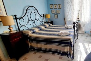 Une chambre à coucher avec un lit, une table de chevet, une lampe et un radiateur.