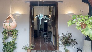 A doorway leading to a room with a tiled floor, hanging decorations, and potted plants.