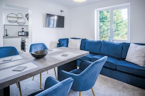 Relax in this stylish living space with a dining area, sofa, and flat-screen TV.