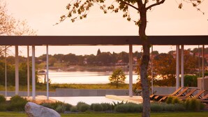 A modern outdoor seating area with a view of a river and distant buildings. - Luxury Villa Zio with Pool (Novigrad)