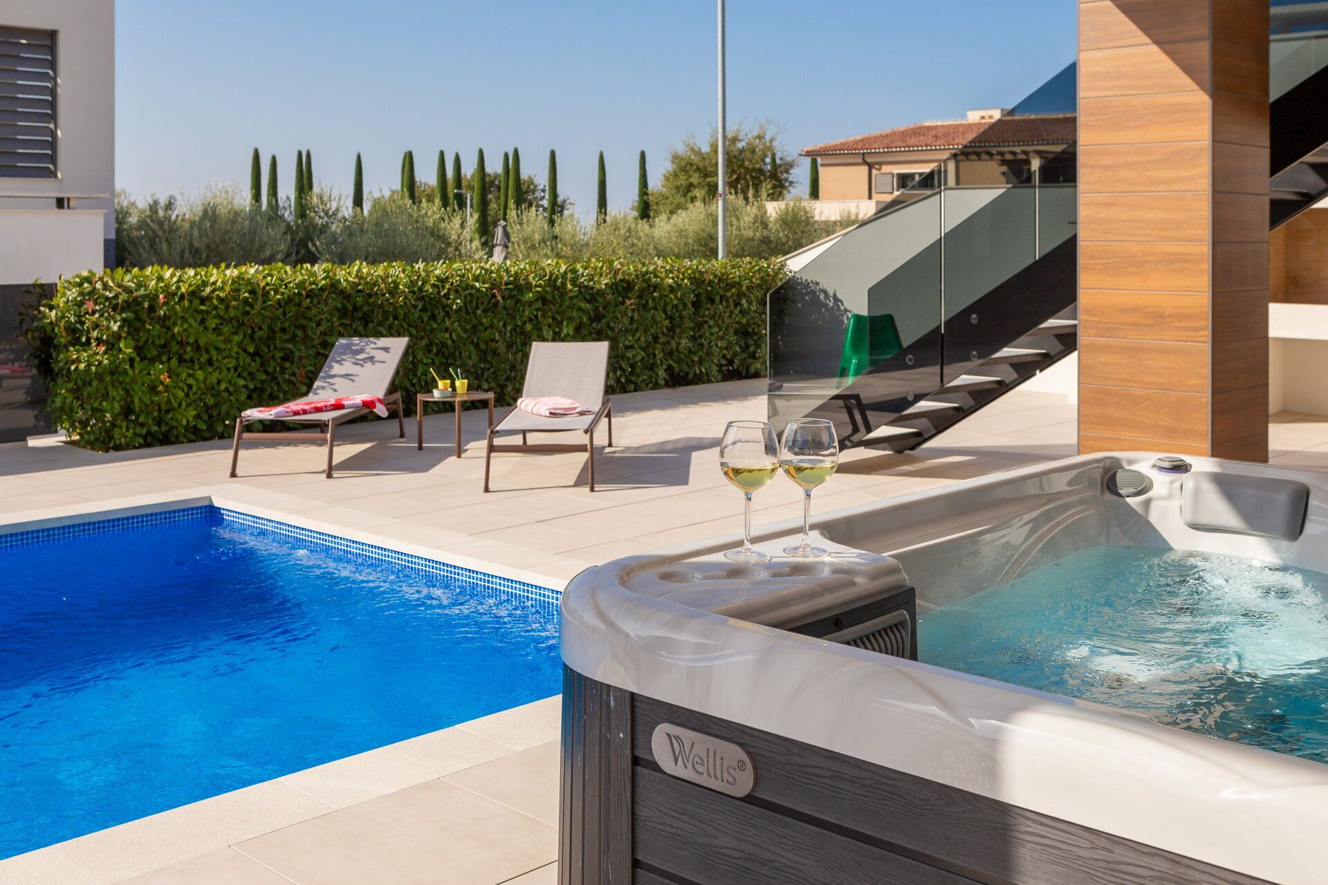 A swimming pool with lounge chairs and a hot tub.