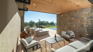 A modern outdoor living area with stone walls, a pool, and outdoor furniture. - Villa Vista Verde with Pool (Grožnjan)