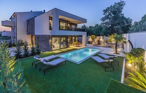 A modern two-story house with a swimming pool, outdoor seating, and a well-maintained lawn. - Luxury Villa Xquisite with Pool (Medulin)
