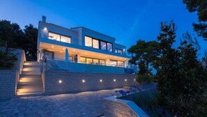 A modern two-story house with a balcony, stone steps, and outdoor lighting. - Villa Hestia with Heated Pool (Lumbarda)
