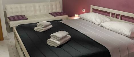 A neatly arranged bedroom with a bed, two nightstands, and a wall-mounted artwork.