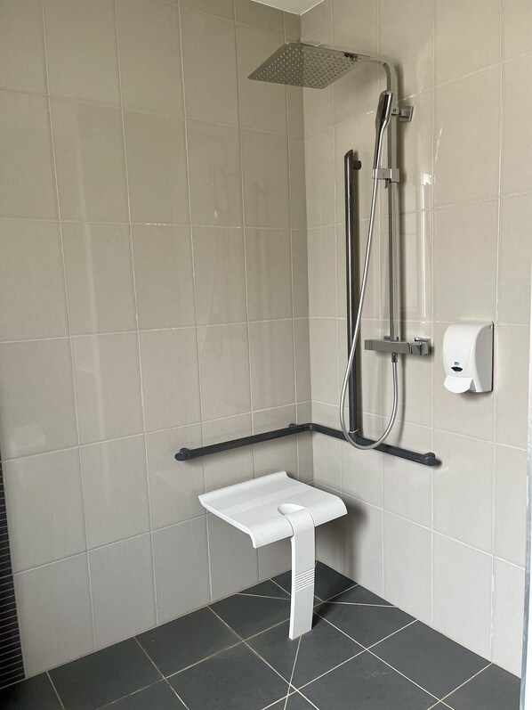 A modern bathroom with a shower, a hand dryer, and a white towel rack. - Auberge de Moussy (Moussy)