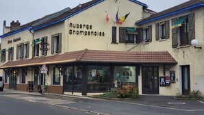 Un edificio con el cartel "Auberge Champenoise" y banderas en la parte superior.