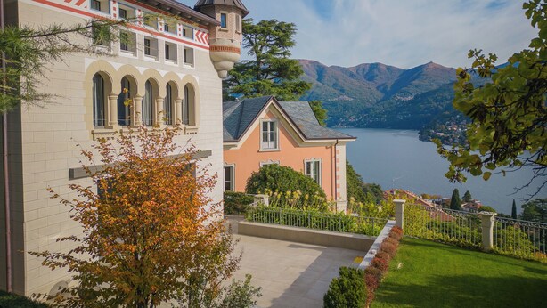 A castle-like building with arched windows and a tower, overlooking a lake with mountains in the background. - Villa Moltrasio - Four Bedroom Villa, Sleeps 8 (Moltrasio)