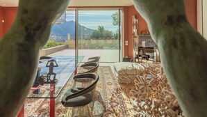 A modern living room with a glass door leading to a balcony, a patterned rug, and a sofa. - Villa Moltrasio - Four Bedroom Villa, Sleeps 8 (Moltrasio)