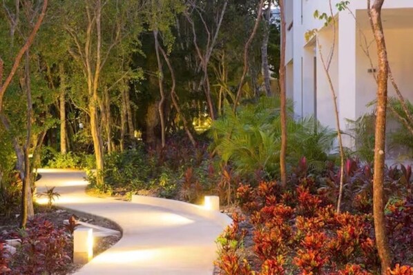 A landscaped garden with a curved pathway leading to a building.
