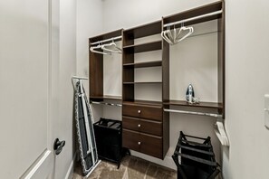 Ein begehbarer Kleiderschrank mit offenen Regalen, Kleiderstangen und einem Schuhregal.