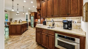 A kitchen with wooden cabinets, a granite countertop, a built-in oven, and a coffee maker. - Mountain Hideaway 8 acres - 5 Bedrooms + Hot Tub (Hendersonville)