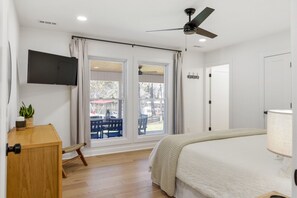 A bedroom with a bed, a desk, a ceiling fan, and a window with curtains. - Urban Rustic Lakeside Retreat with Dock, Sleeps 20 (Gallatin)