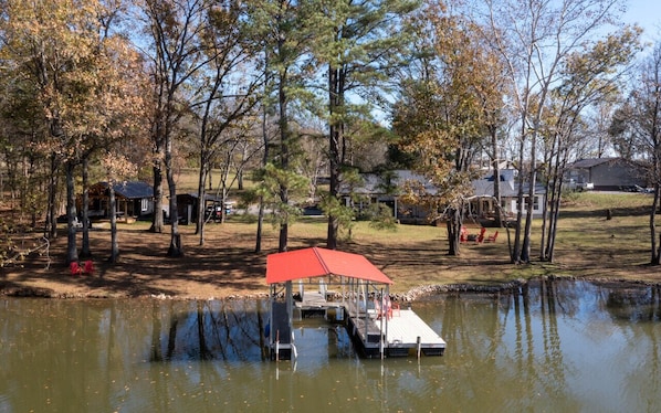 A lakeside cabin with a dock and a red canopy.