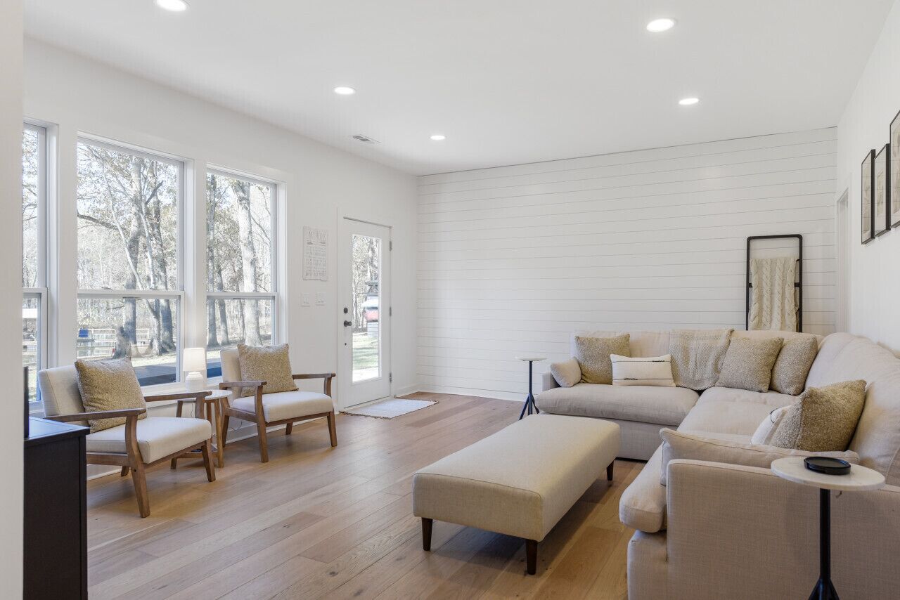 Uma sala de estar moderna com um sofá, cadeiras e uma mesa de centro.