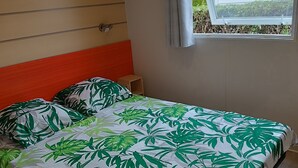 A bedroom with a bed, a window, and a small table.
