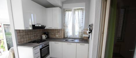 Een koelkast, een oven, een kookplaat, een vaatwasser