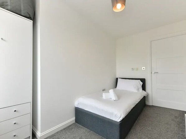 A bedroom with a bed, a wardrobe, and a door. - Spacious Cardiff Bay Apartment! - Pass the Keys (Cardiff)
