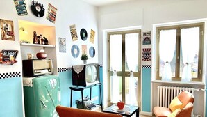 Un salon à l’ambiance rétro, avec des meubles anciens, une radio d’époque et des décorations murales.