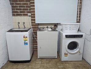 Convenient laundry facilities feature a front-loading washing machine and top-loading dryer.
