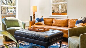 A living room with a leather sofa, two armchairs, a coffee table, and a patterned rug. - Hickory House - Family/Group and Pet-Friendly Retreat Near Lockhart Square! (Lockhart)