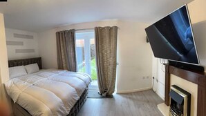 Un dormitorio con cama, televisión y chimenea.