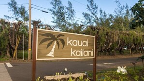 A wooden sign with a palm tree and the words "kauai kailani". - 3 Bedroom Ocean Front Condo with Pool & Elevator! (Kapaʻa)