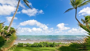 A beach view with lounge chairs and palm trees. - 3 Bedroom Ocean Front Condo with Pool & Elevator! (Kapaʻa)