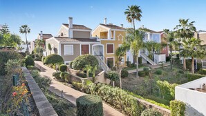 A residential area with multiple houses, a pathway, and well-maintained gardens. - Casa Livia with Auping beds (Estepona)
