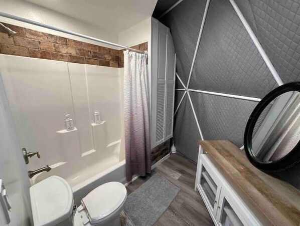 A modern bathroom with a shower, toilet, and sink.