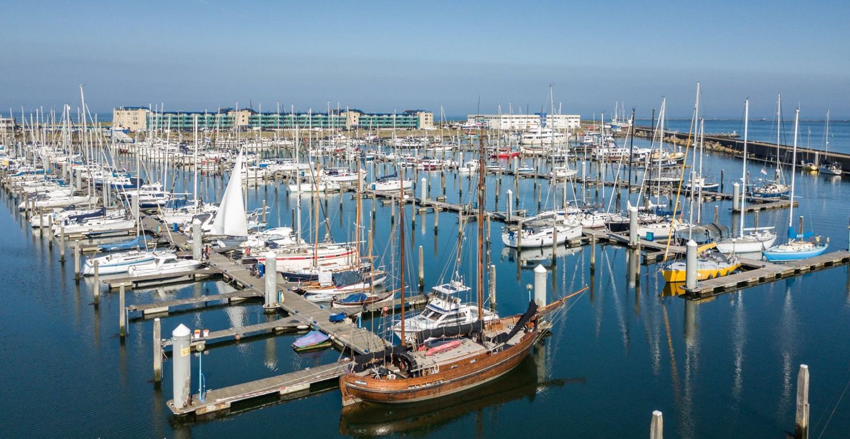 A marina with numerous boats docked at wooden piers.