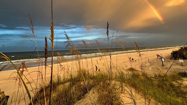 A beach with a rainbow, sand dunes, and ocean waves. - Crescent Beach Retreat - Steps to Sand - Pet Friendly (St. Augustine)