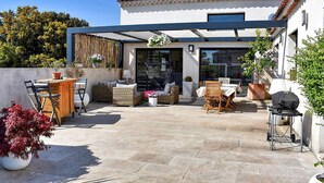A modern patio with outdoor furniture, a dining table, and a barbecue area. - La Villa De Notre Dame (Chateaurenard)