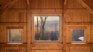 A wooden cabin with a large central window and two smaller windows on either side. - Mountain Retreat, Sunset Views, and 20 Minutes to Asheville! (Swannanoa)