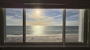 Une pièce dotée d’une grande fenêtre donnant sur une plage.