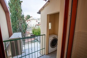 Enjoy fresh air and laundry convenience from this balcony with a washer and dryer.