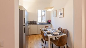 Una cocina compacta con comedor, ventana y lámpara colgante.