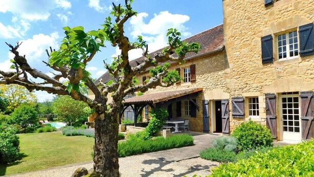 A stone building with a covered patio and outdoor seating area.