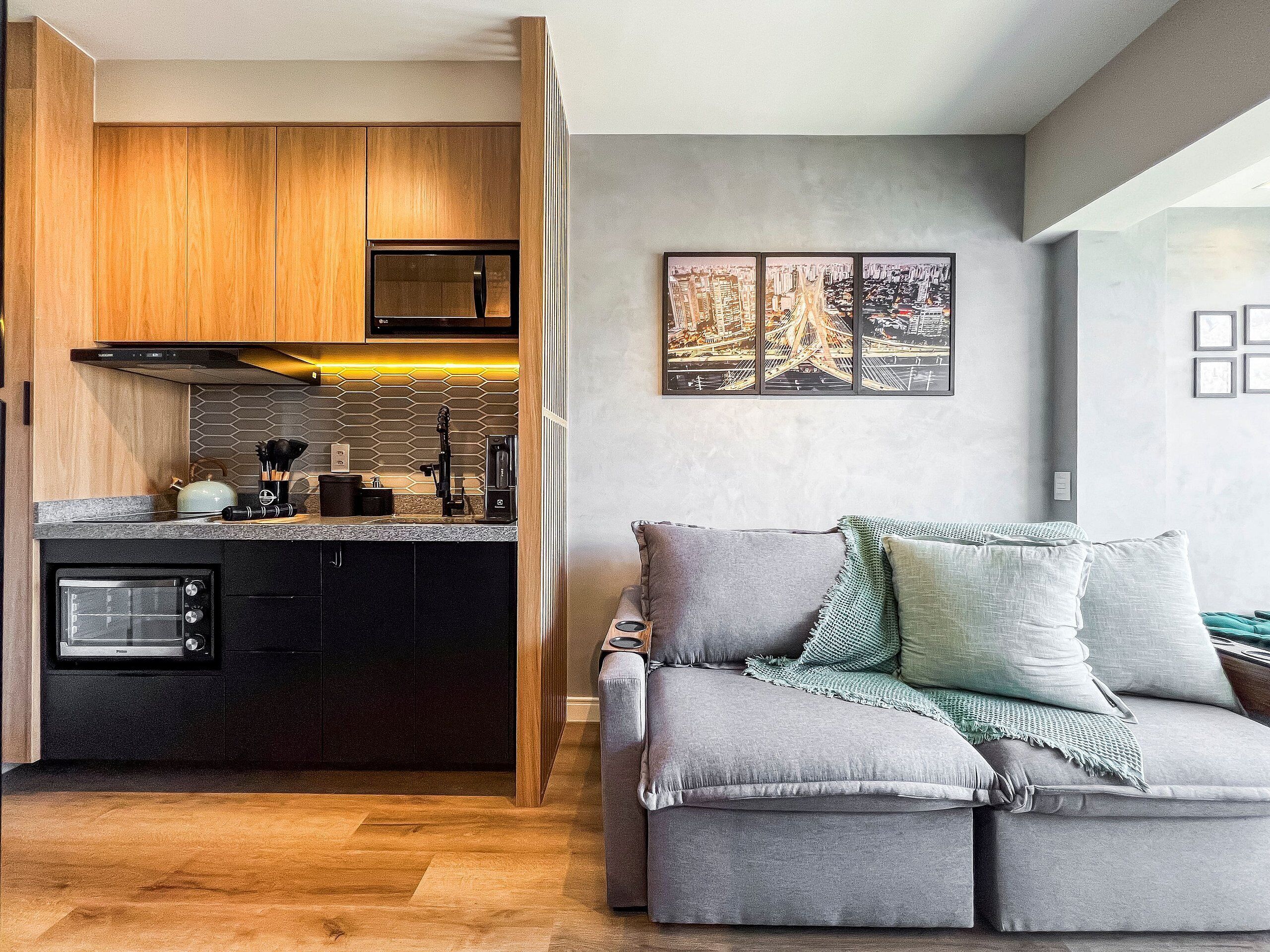 A modern kitchen with wooden cabinets, a built-in microwave, and a coffee machine.