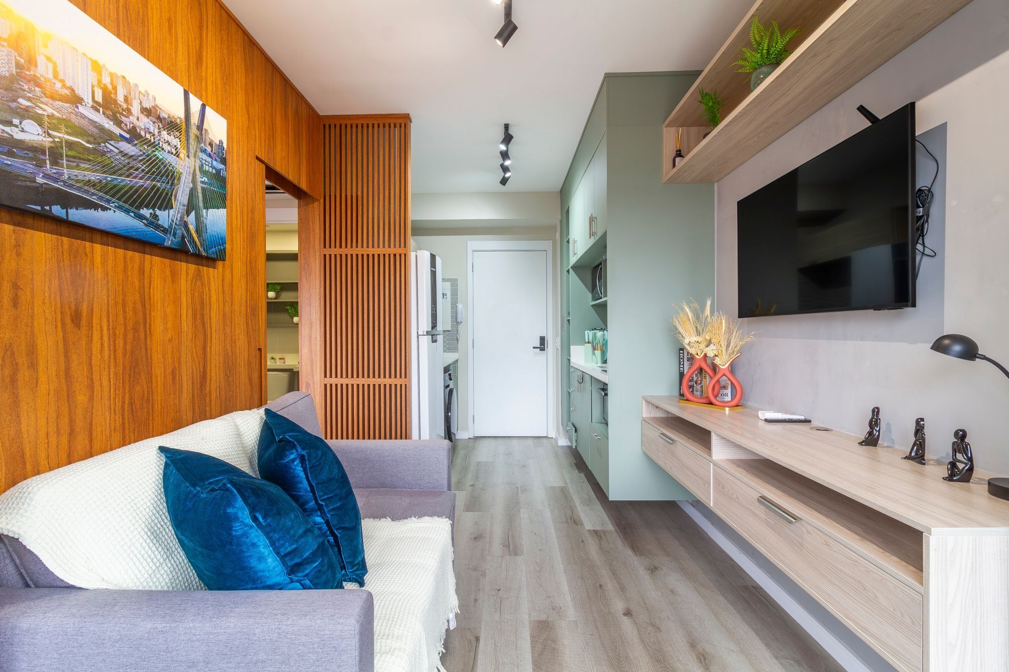 Una sala de estar moderna con sofá, televisor y paneles de madera.