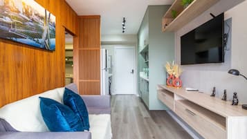 Una sala de estar moderna con sofá, televisor y paneles de madera.
