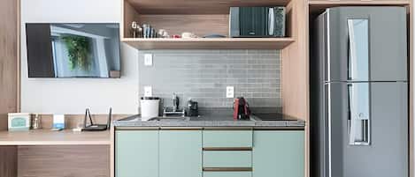 A modern kitchen with a built-in refrigerator, a wooden countertop, and a wall-mounted TV.