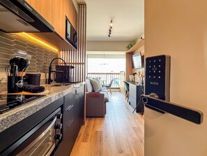 Une cuisine moderne équipée d’un four encastré, d’un four à micro-ondes et d’une machine à café.