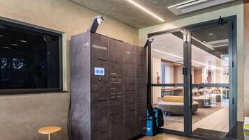 A modern interior with a large storage unit, a seating area, and a glass door leading to another room.