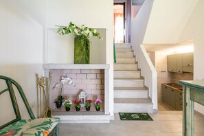 Un escalier avec un mur blanc et une chaise verte sur le côté gauche.