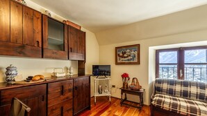 Una habitación acogedora con armarios de madera, televisor, sofá y ventana con vistas.