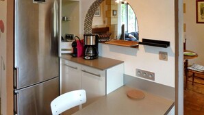 A compact kitchen with a stainless steel refrigerator, a coffee maker, and a microwave on the countertop. - Beautiful home in Domme with WiFi (Domme)