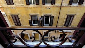 A yellow building with multiple windows, some with shutters, and a metal railing in the foreground. - Luxury & Charm between Pantheon and Spanish Steps (Roma)