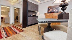 A modern kitchen with a dark countertop, a dining area with a table and chairs, and a colorful rug on the floor. - Luxury & Charm between Pantheon and Spanish Steps (Roma)